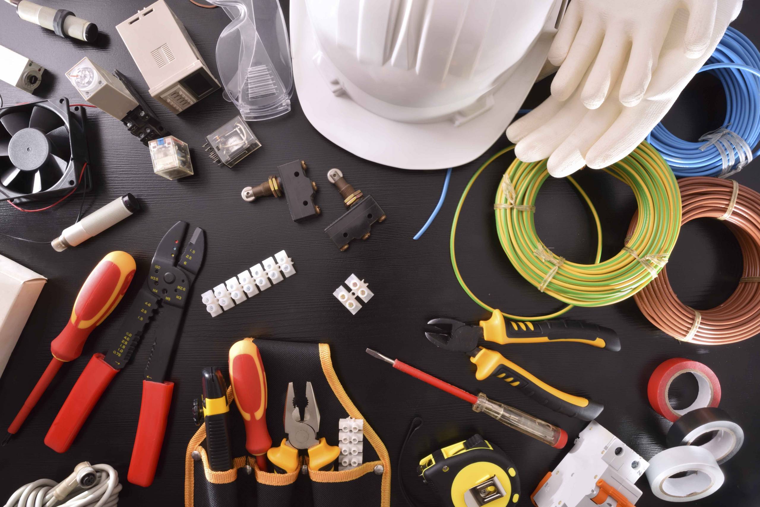 Industrial electricity tools on black table close up top